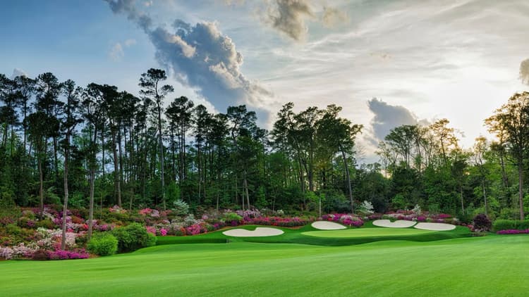 Lush fairway leading to the green over water at Augusta National with azaelias around the outside of the hole
