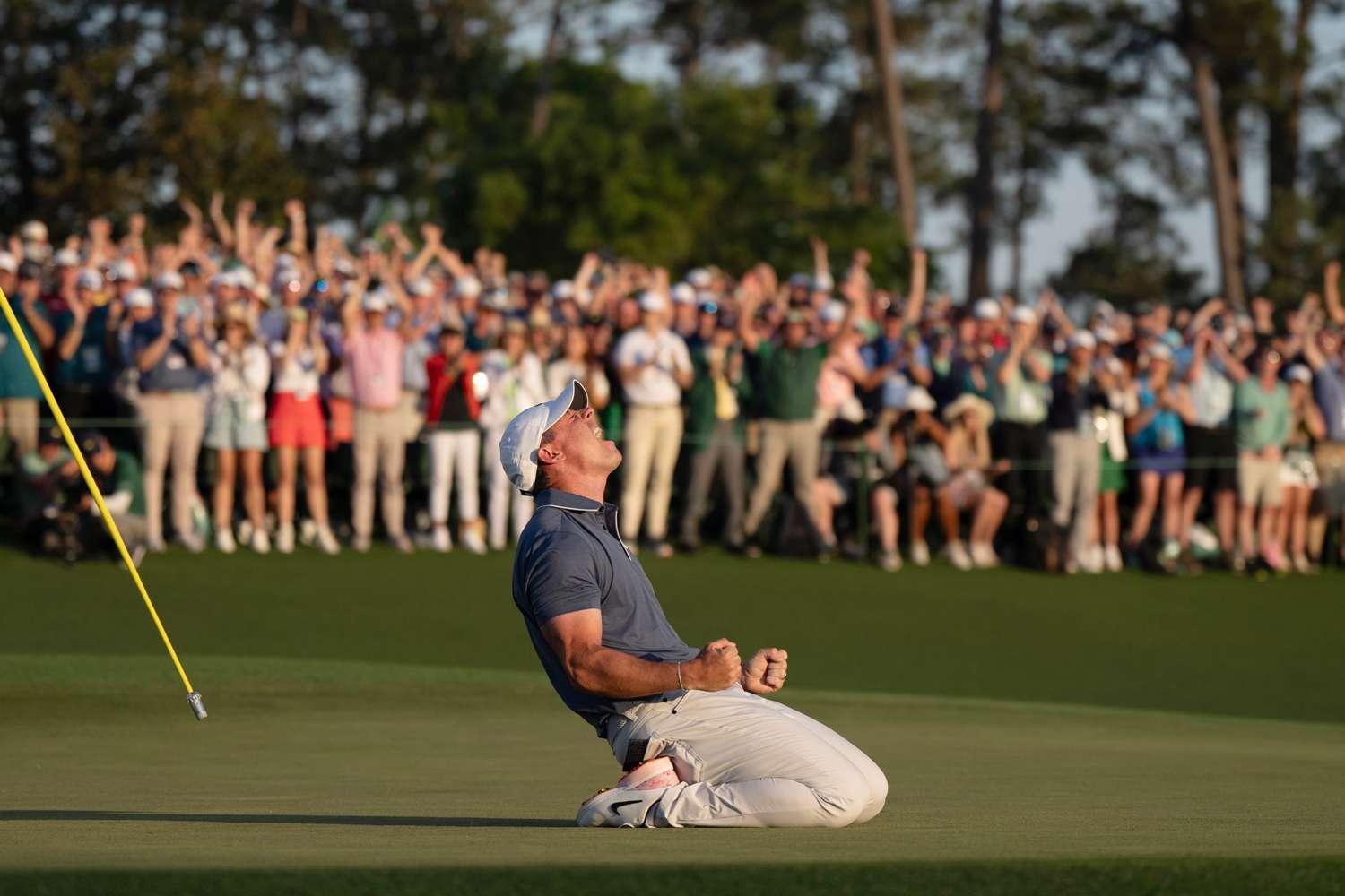 Rory McIlroy on his knees immediately after sinking the winning putt at the 2025 Masters