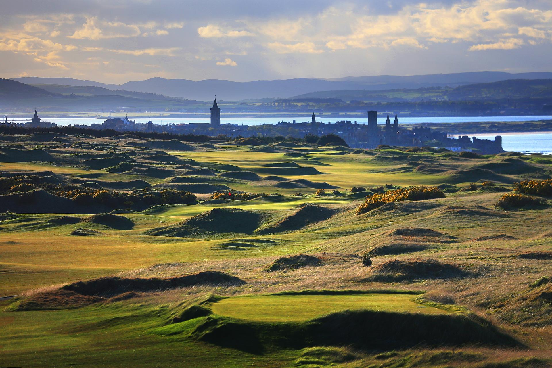 Wide view of the undulating fairways, a classic links layout at the Castle Course with the town of St Andrews visible in the background