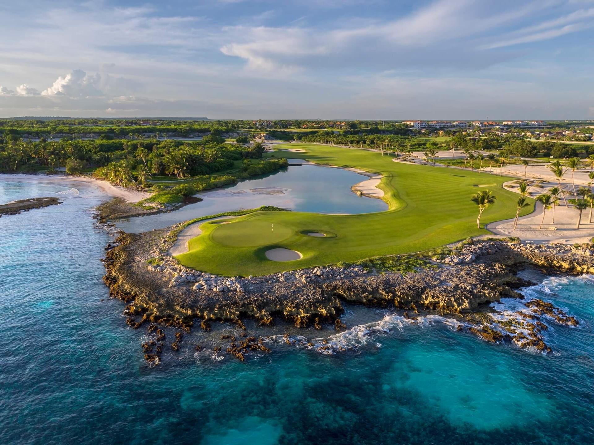 Overhead view of a manicured coastal green with a winding fairway leading to it