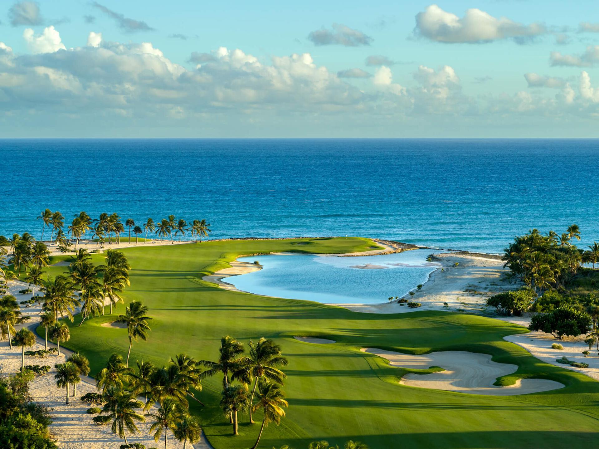 Overhead view of a ell maintained leading to a smooth green with coastal views