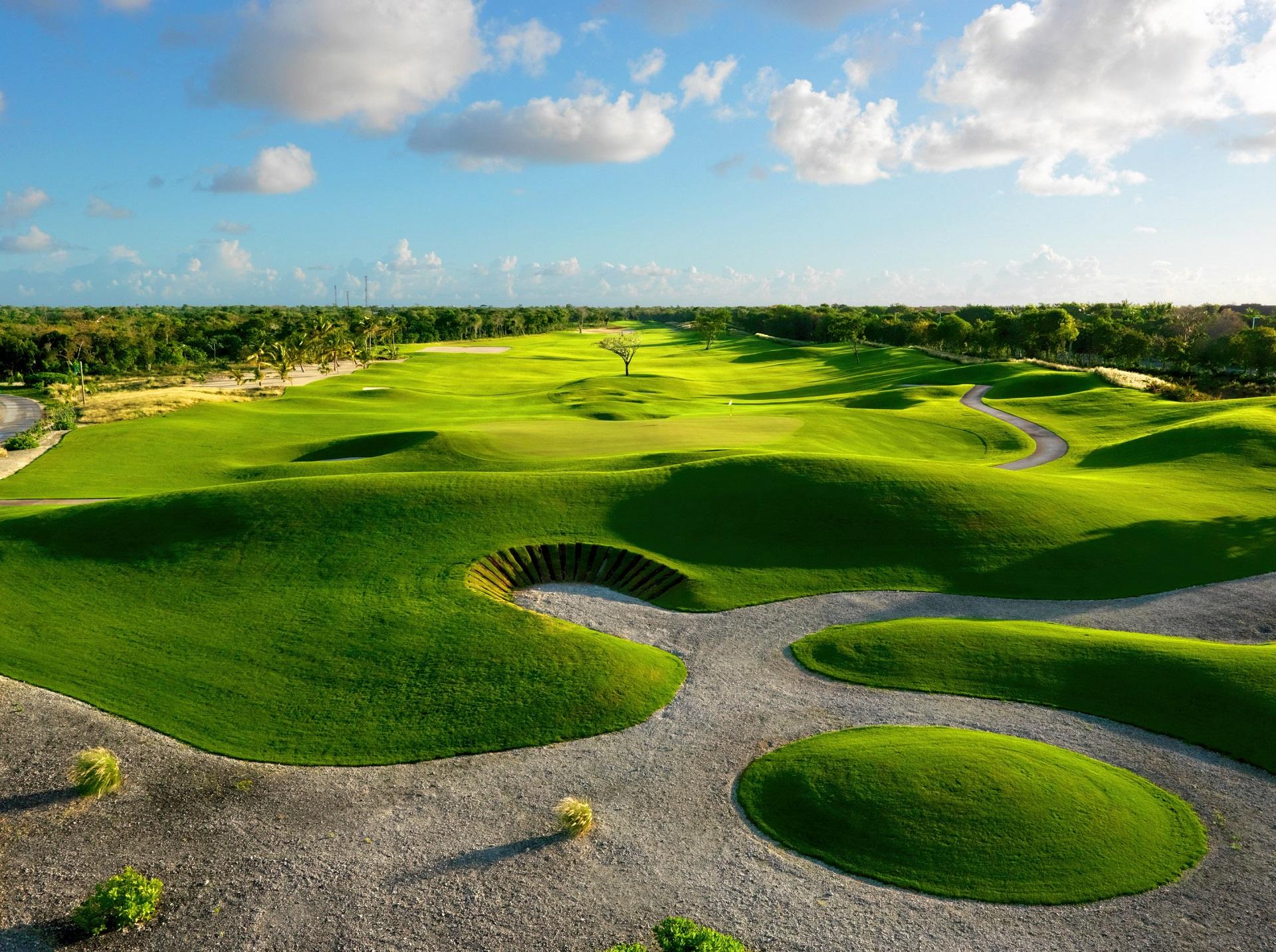 Rolling dunes surrounding a smooth green with deep sand bunkers