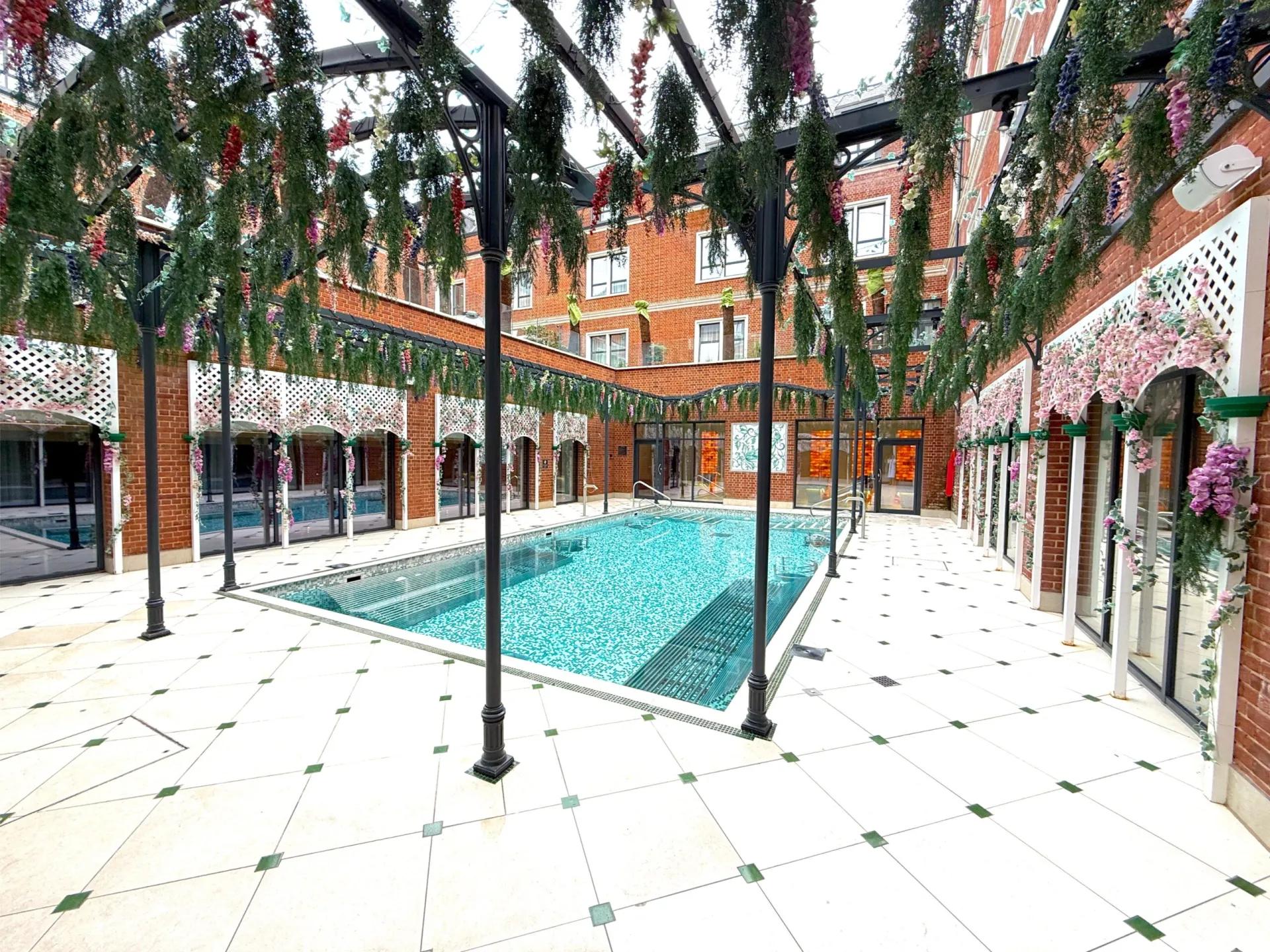 Outdoor swimming pool at the hotel surrounded by vibrant flowers