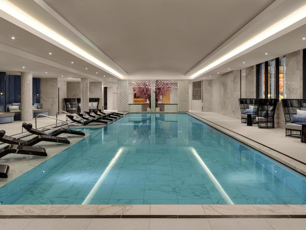 Luxurious marble indoor swimming pool surrounded by sunbeds at the hotel