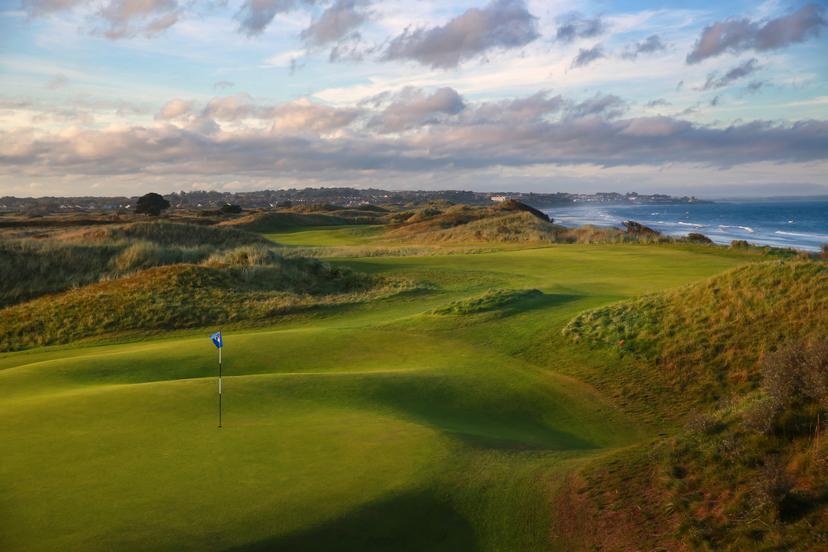 A winding fairway leading to a smooth green with coastal views