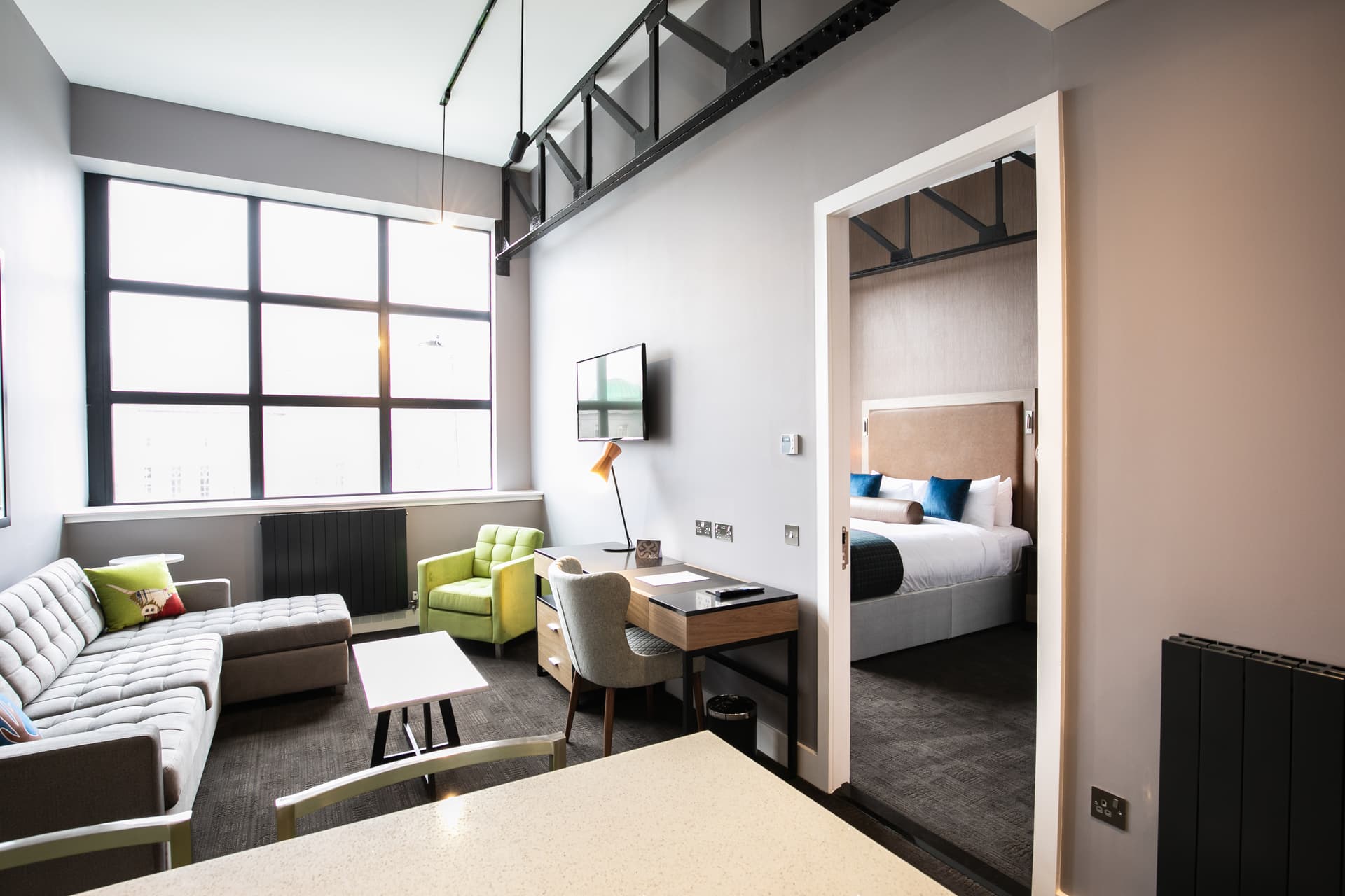 Double bed suite at Sandman Signature Aberdeen Hotel with a separate living room and bedroom with natural light flooding in from the windows