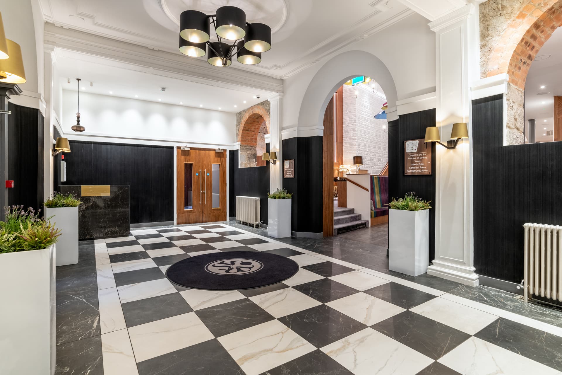 Front entrance to Sandman Signature Aberdeen Hotel with a black and white floor design