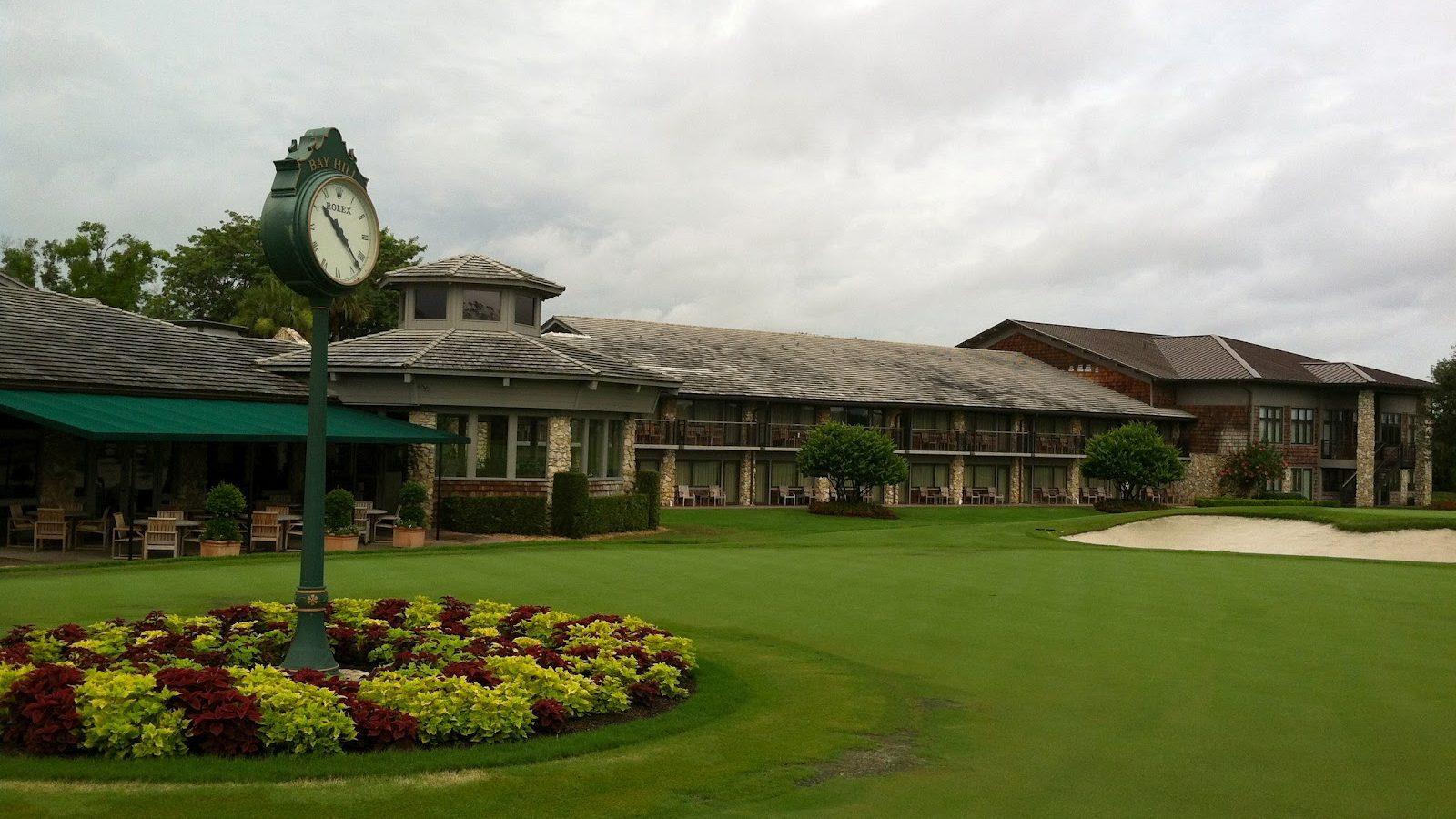 The Arnold Palmer's Bay country club looking over the course alongside a Rolex clock surrounded by a bed of flowers