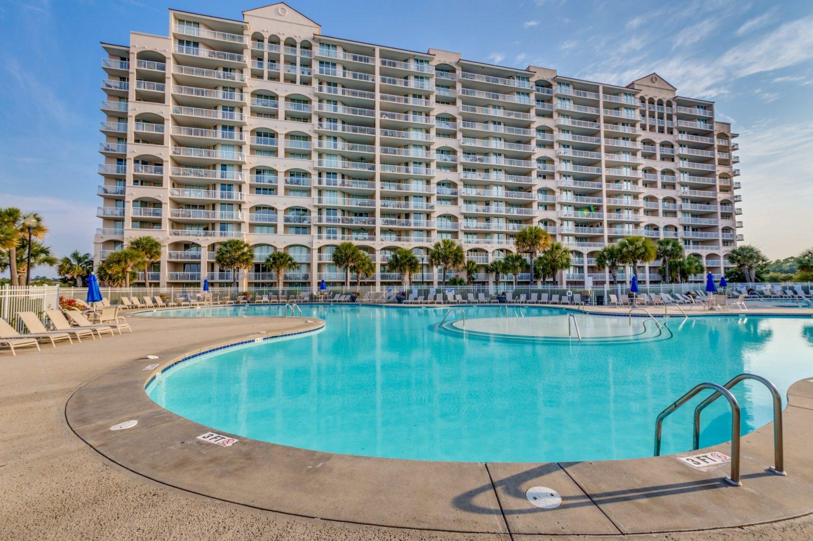 Outdoor swimming pool with the resort building towering over