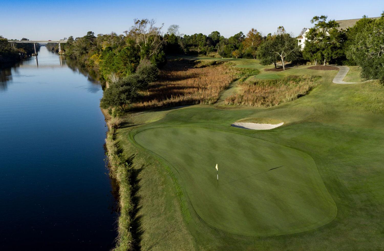 Overhead view of a smooth green neighbouring a water hazard