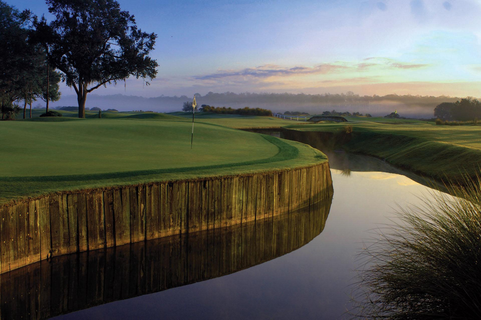 Sun setting over the course reflecting the river with a stone bridge to navigate around Grand Cypress Links