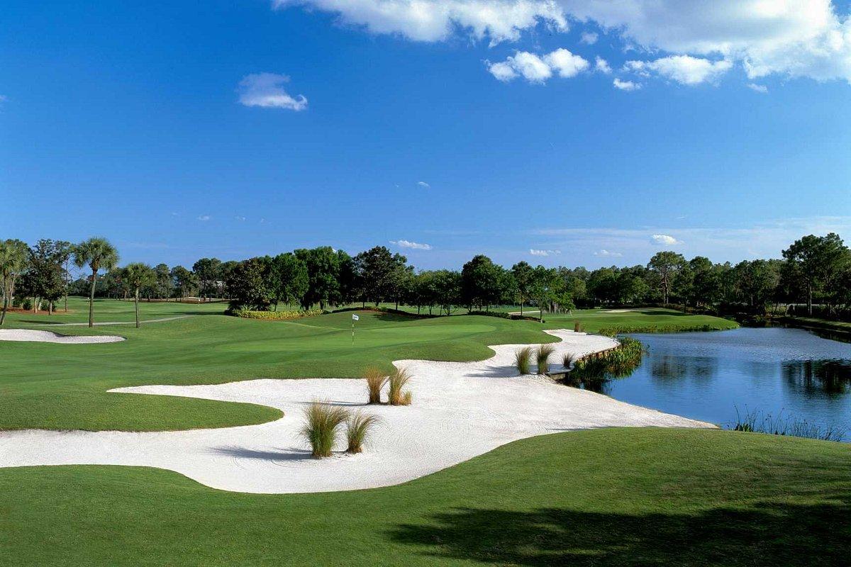 Large uniquely shaped sand bunker being sandwiched by a water hazard and manicured green