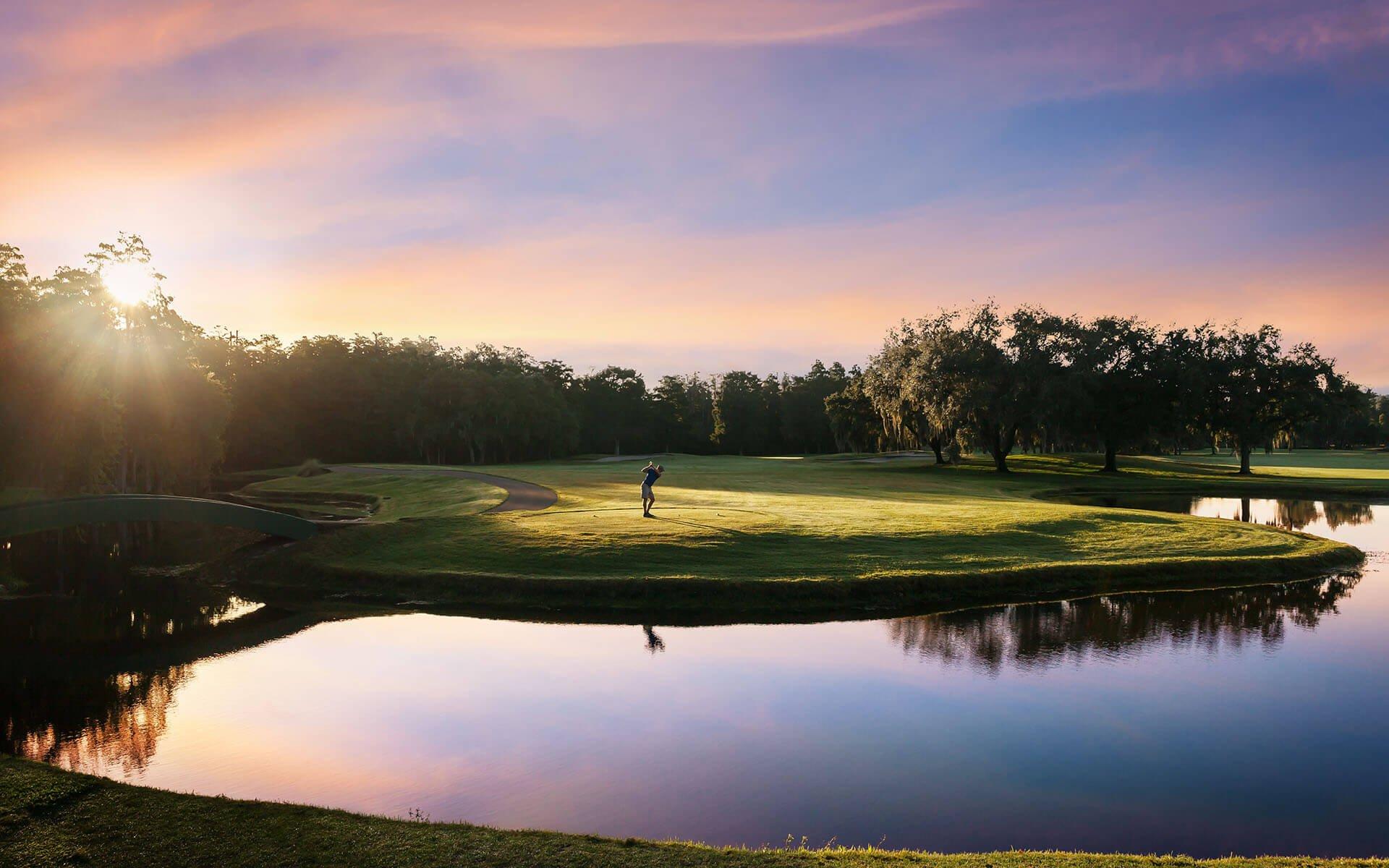 Golfer teeing off under the sun set at the Innisbrook Golf Resort