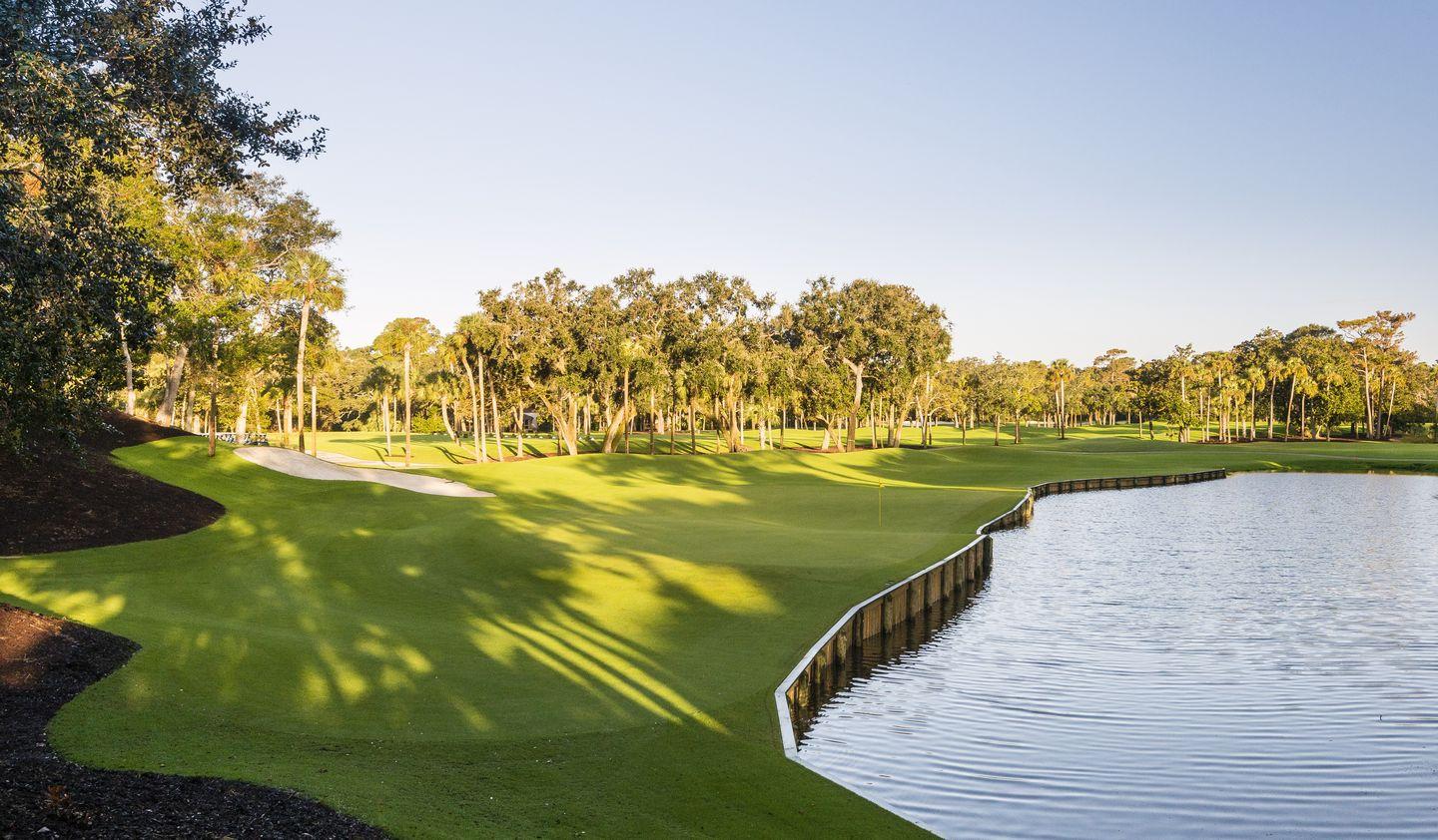 Green elevated from water hazard at with a sand bunker placed next to it