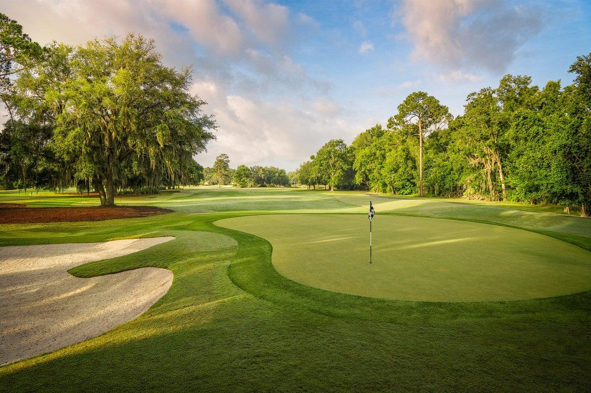 Panoramic view of a wide fairway leading to a smooth green at the King & Bear Course