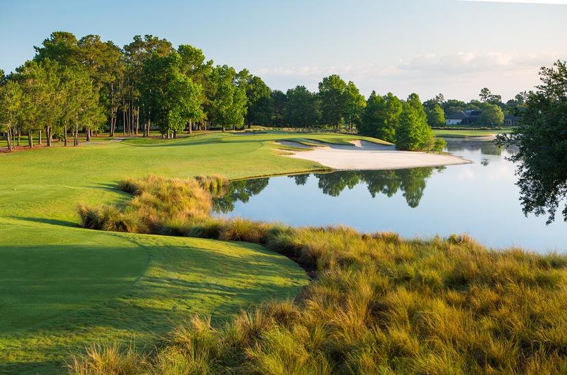 Sand bunker sandwiched between a large pond and manicured green