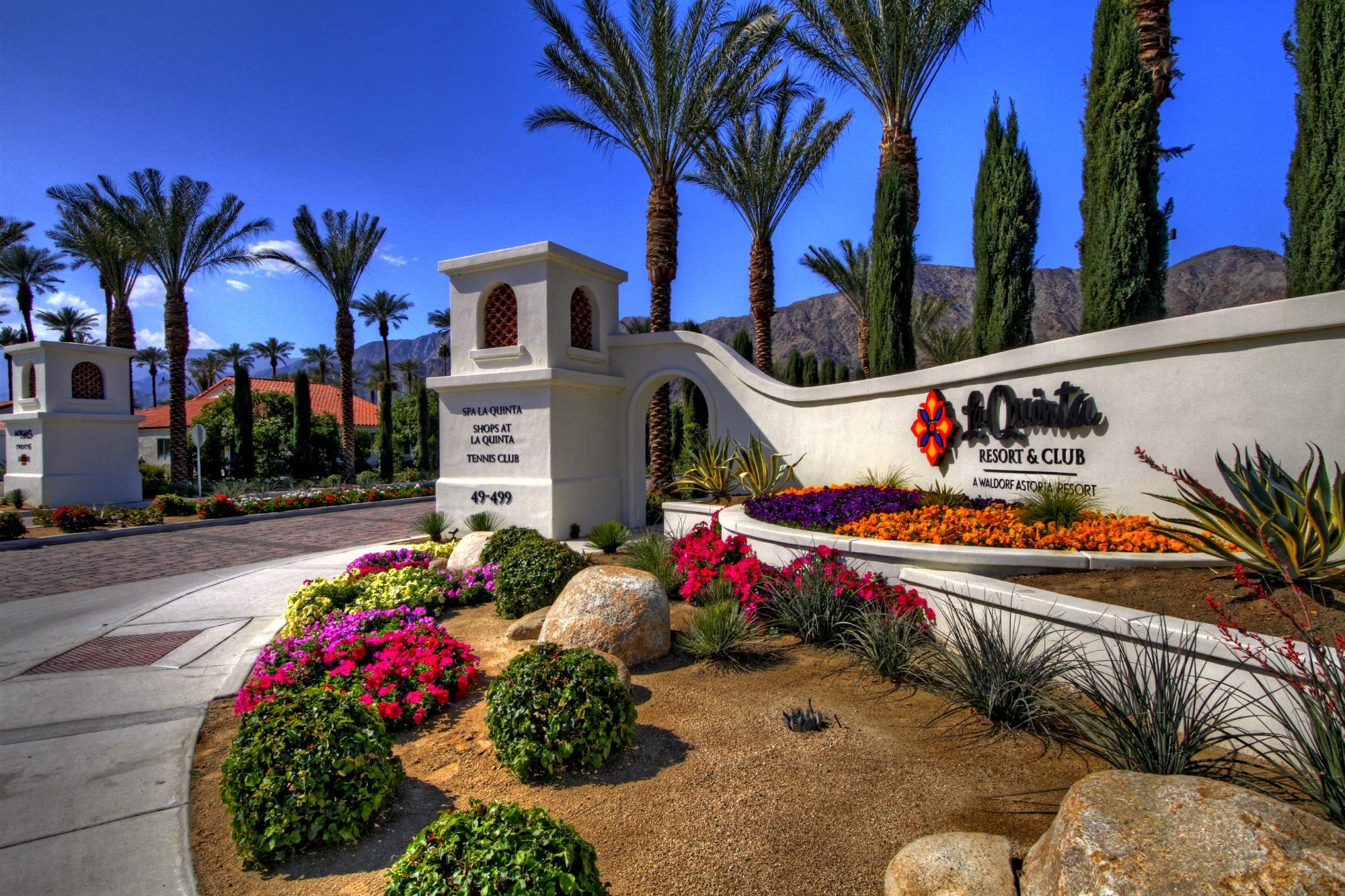 Front entrance to the resort featuring their company logo and name surrounded by vibrant flowers