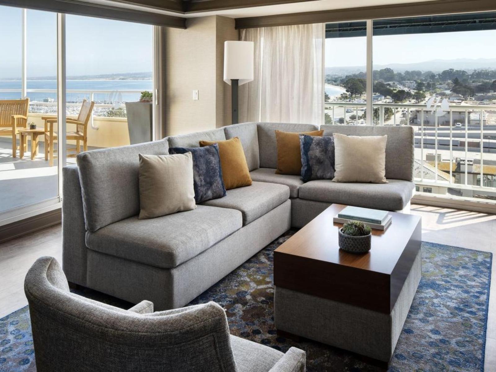 Living room as part of a room at the hotel with panoramic window views of the city