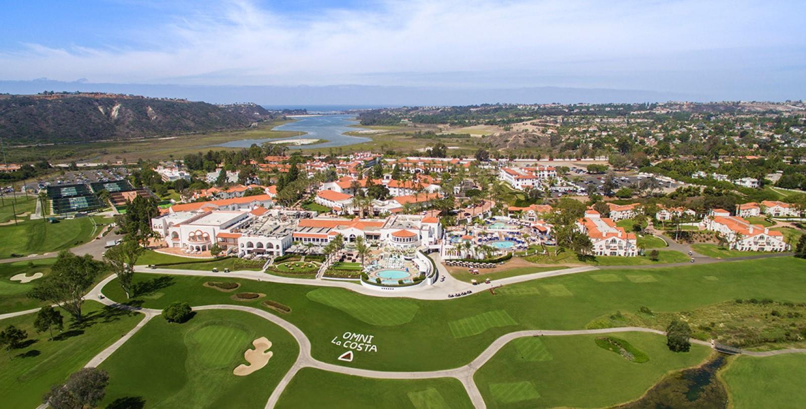 Aerial view of the Resorts land featuring their branded golf course, multiple tennis courts and several swimming pools