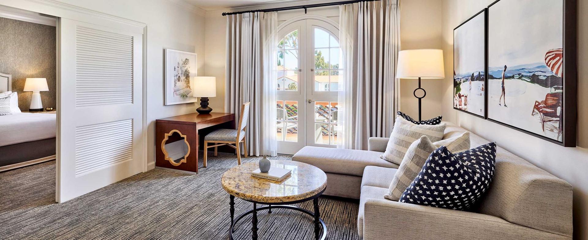 Living room as part of a double bed suite with a large sofa, office area and a balcony with seating