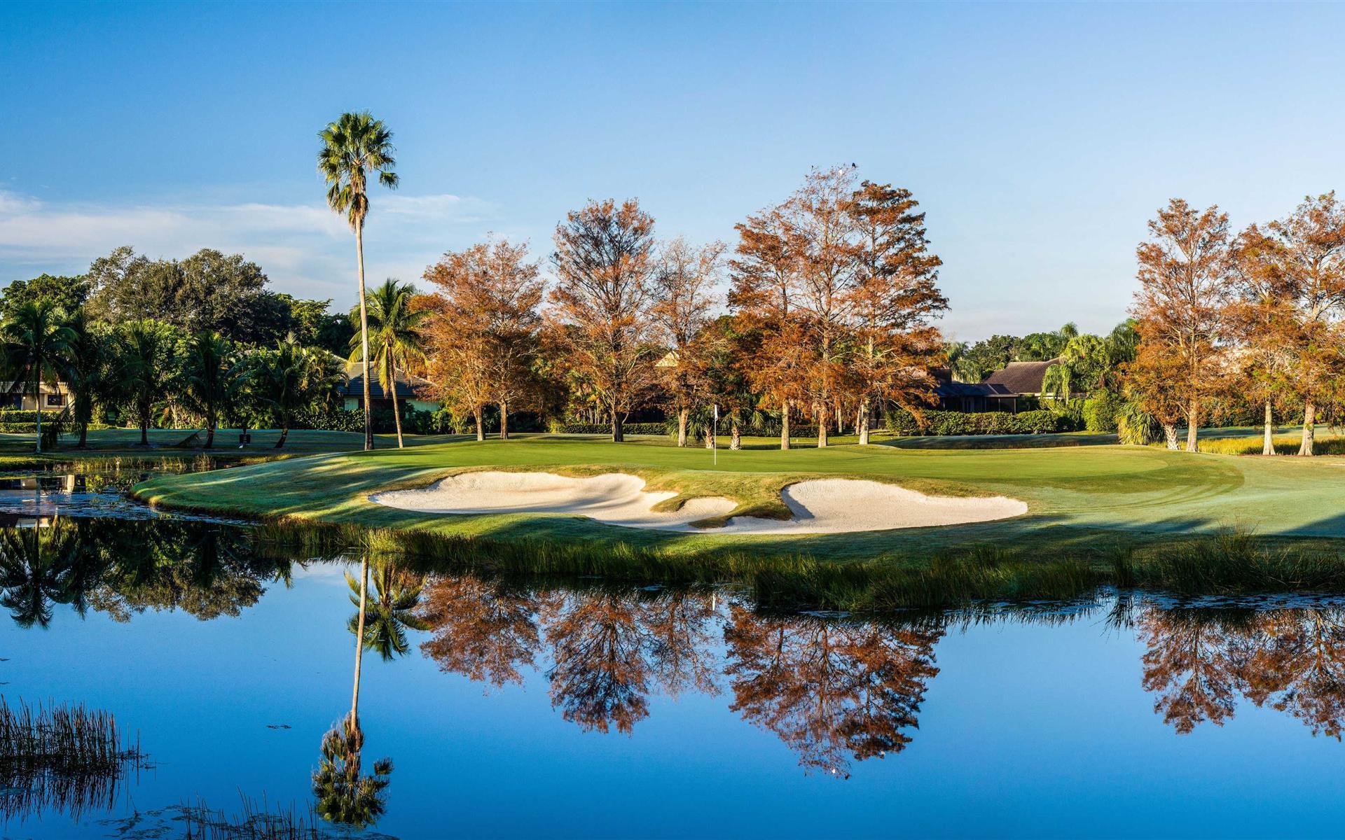 Uniquely shaped sand bunker separating the water hazard from an elevated green