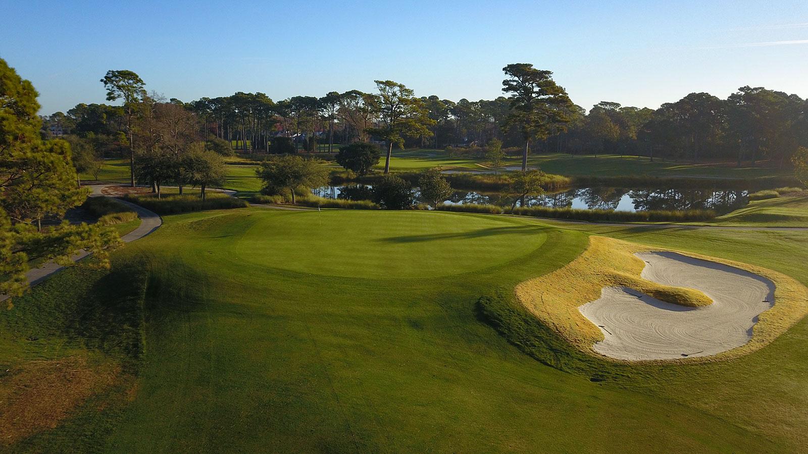 Aerial view of an elevated green surrounded by sand bunkers