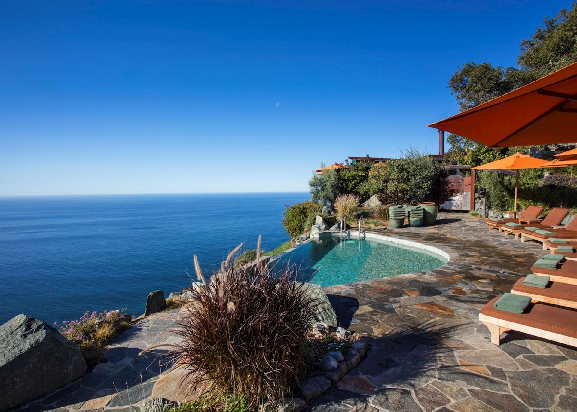 Panoramic view of a hillside swimming pool with ocean views