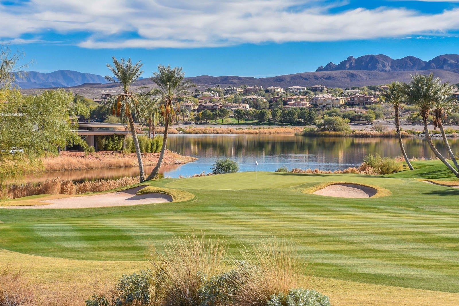 Lakeside golf hole with perfectly manicured fairways and desert mountain homes in the distance