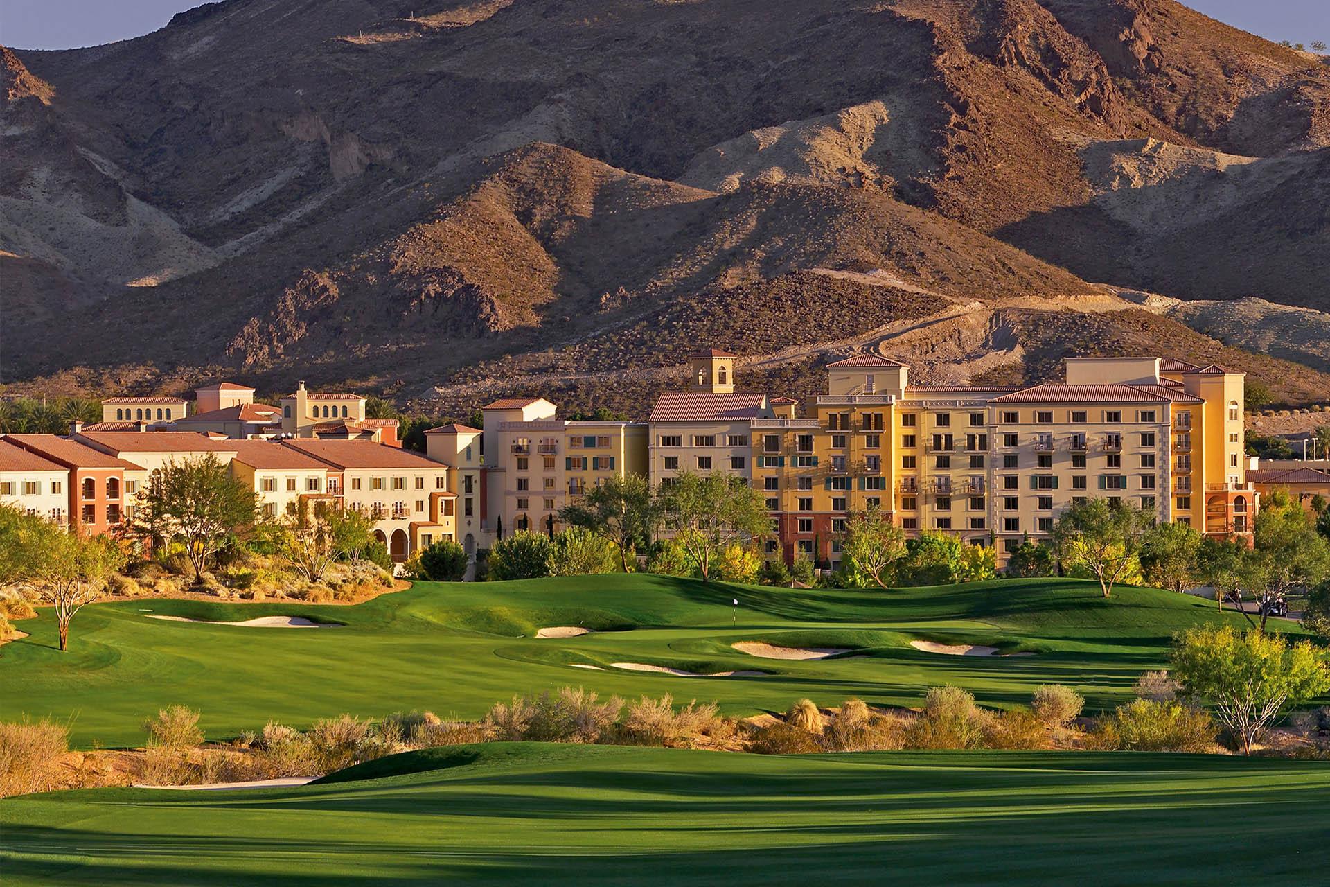 Lush fairways leading toward a luxury resort with rugged desert mountains as the backdrop.