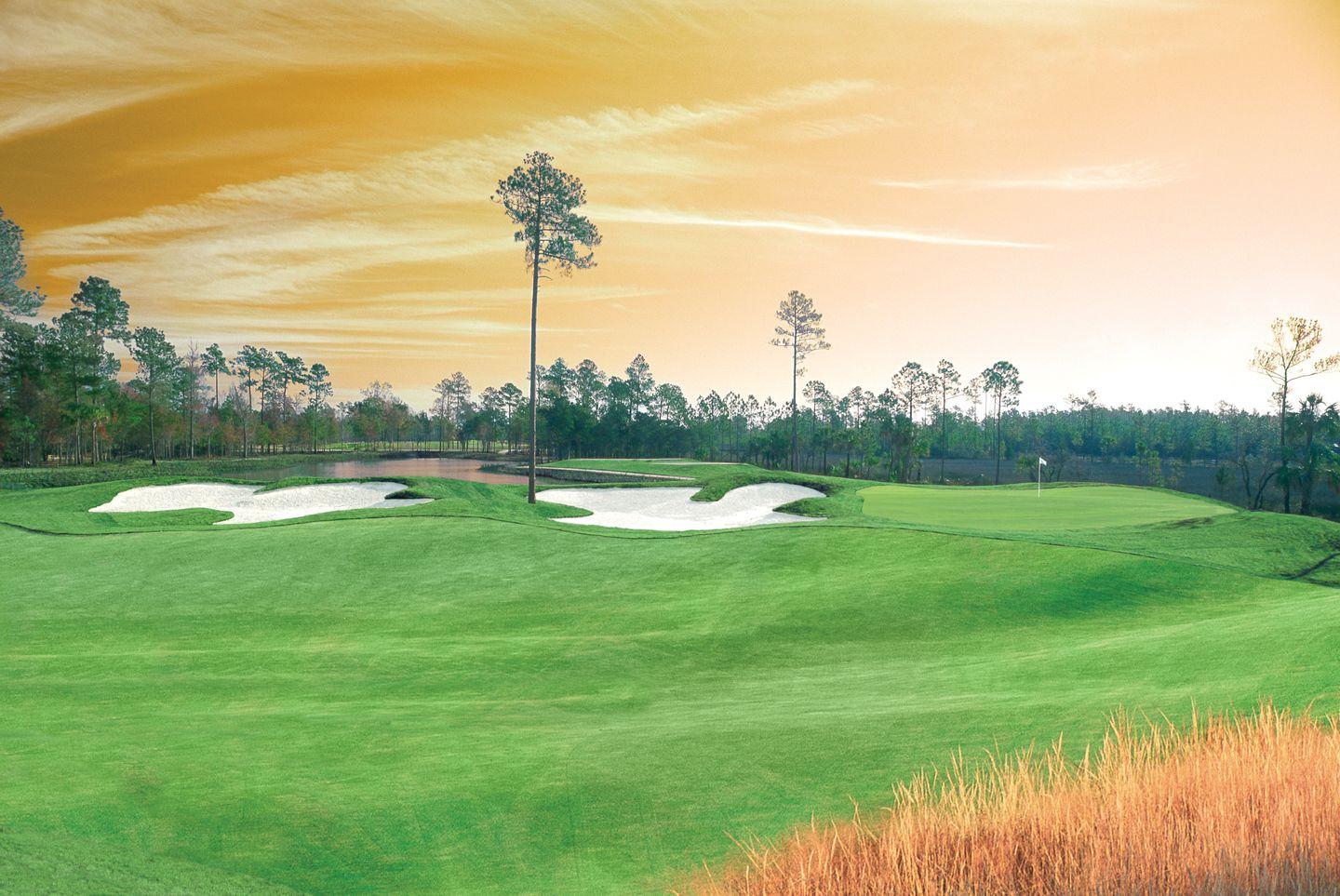 Golden sun setting over the RiverTowne course with its uniquely shaped sand bunkers and rolling dunes