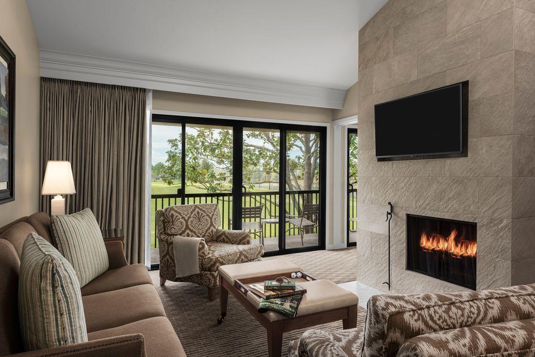 Living room as part of a suite with a fire place & balcony views of the course at the Silverado Resort