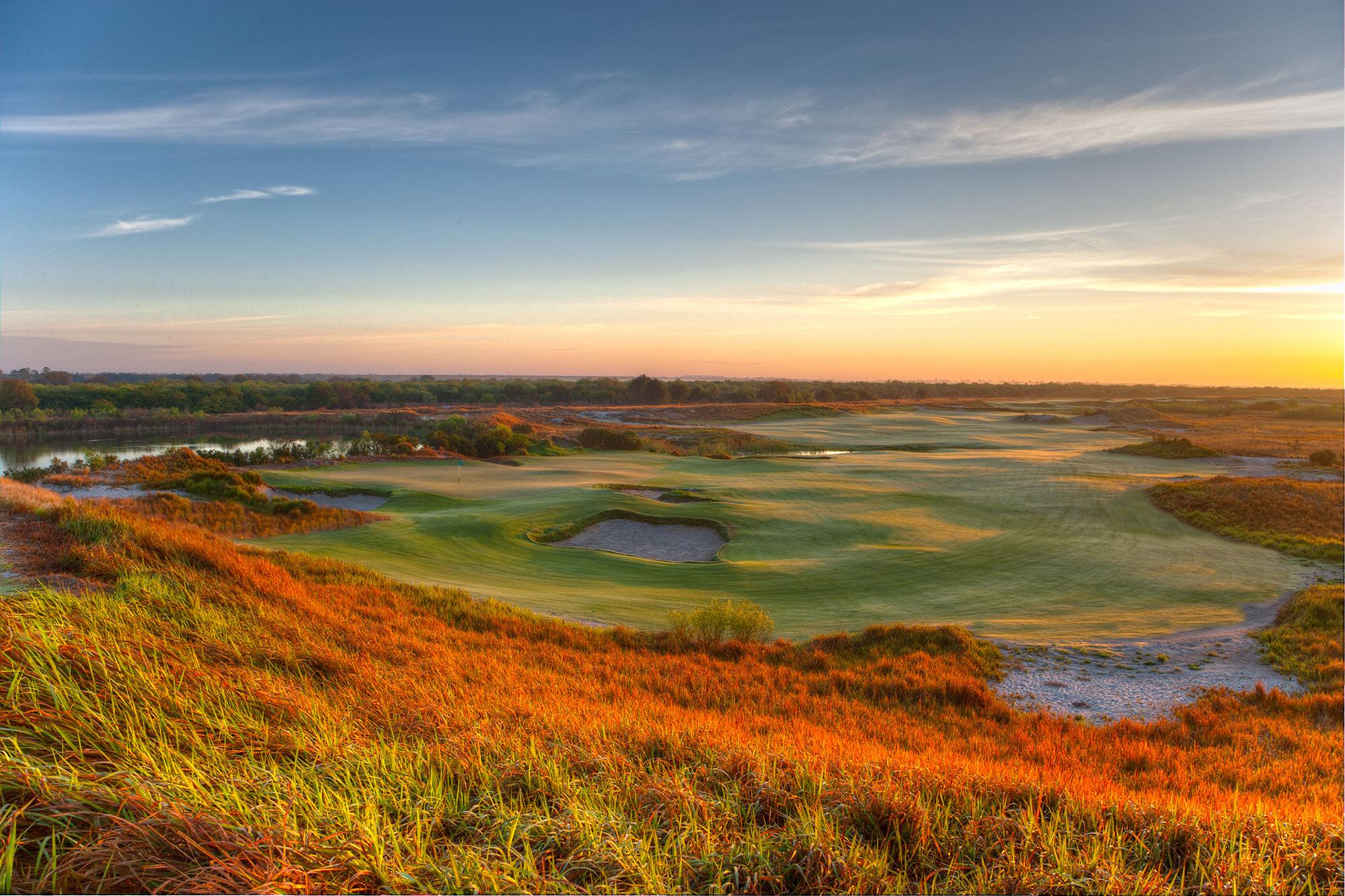 Rolling fairways with golden grasses glowing at sunrise.