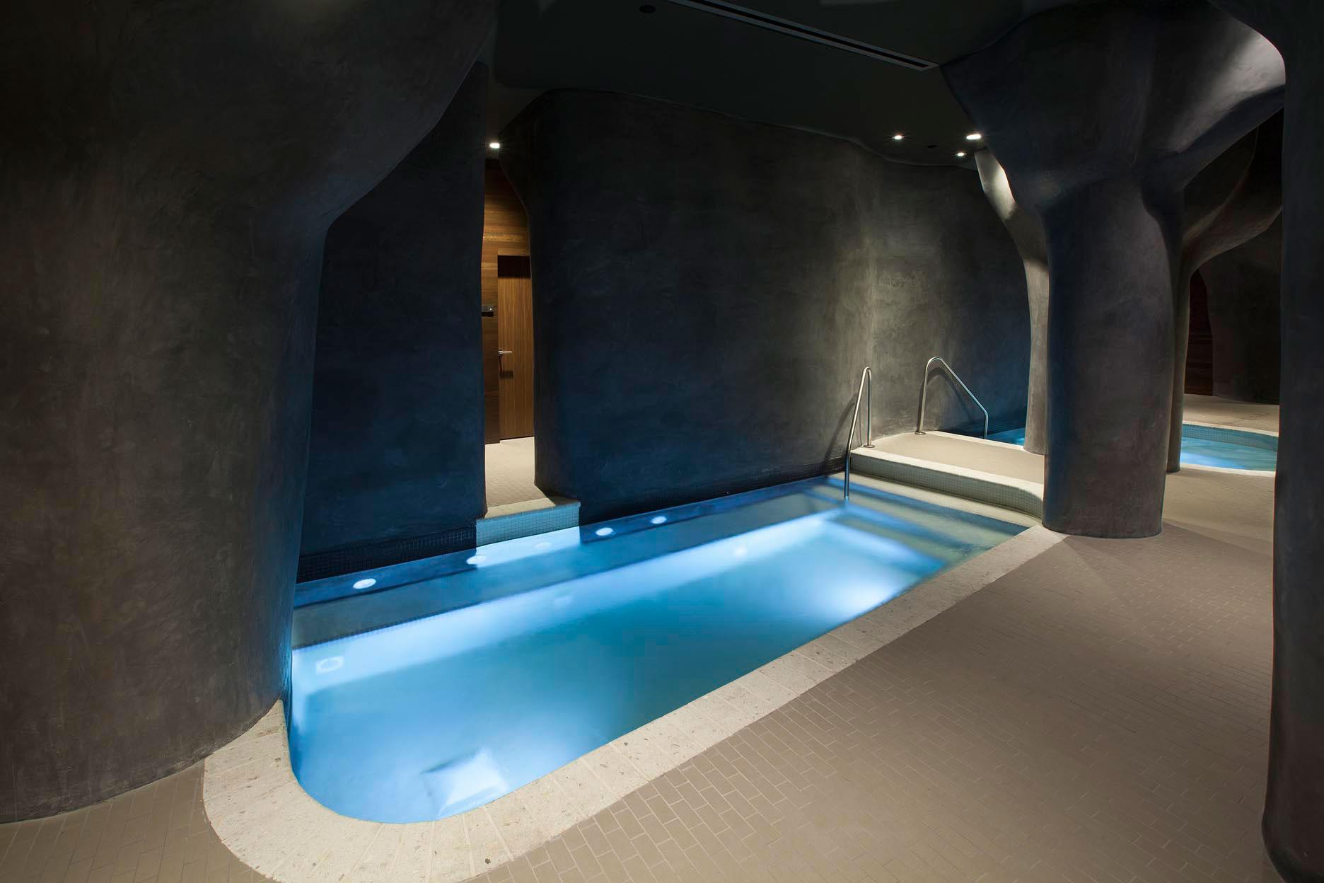 Indoor jacuzzi and swimming pool with a cave design as part of the spa facilities at the hotel