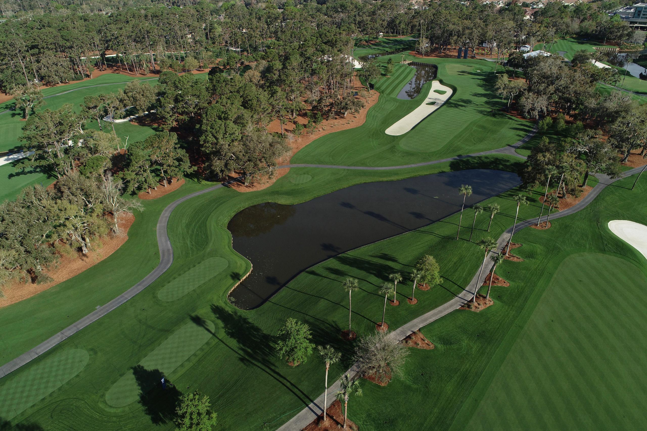 Birdseye view of the course with multiple sand bunkers and water hazards littered with trees