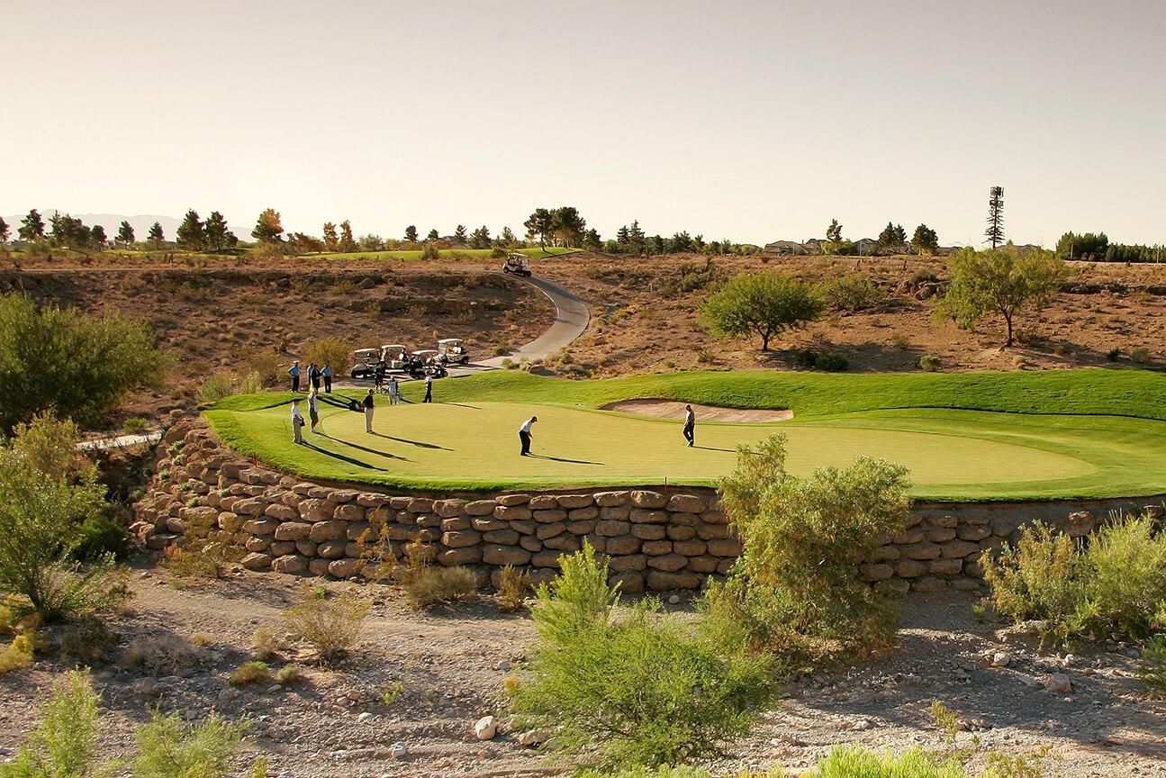 Large group of golfers putting on a smooth elevated green at the TPC Las Vegas course