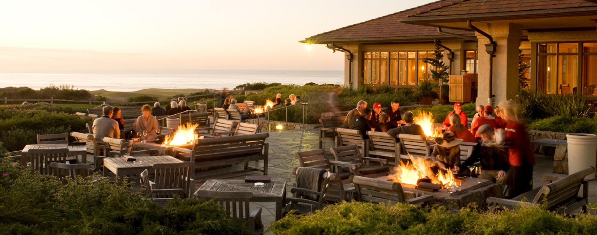 Outdoor seating area at The Inn with multiple fire pits for guests to enjoy and views of the course and sea