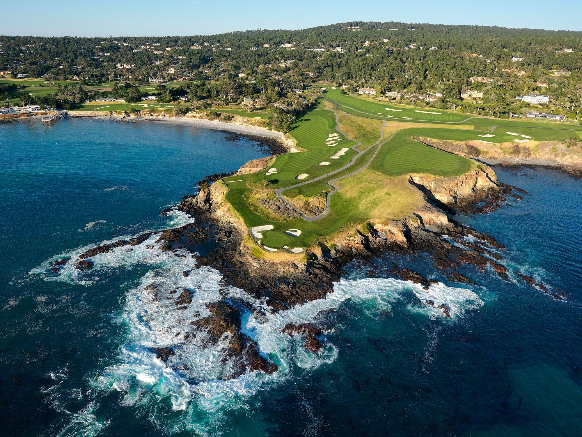 Birdseye view of the course with a rocky shoreline with waves crashing in towards the course