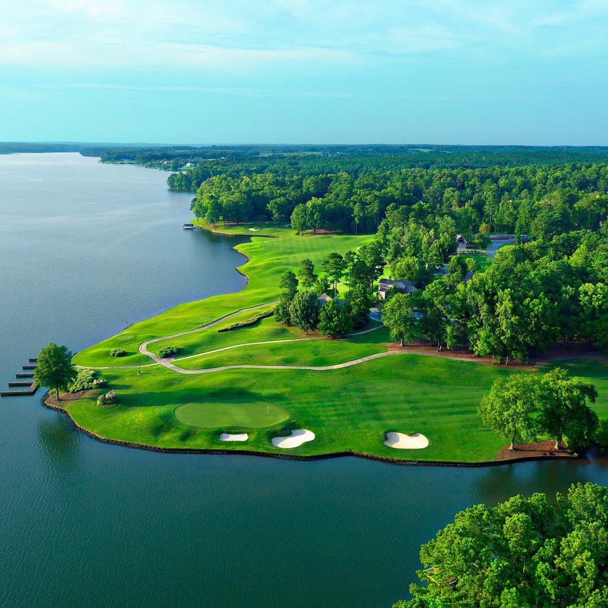 Overhead view of a smooth green with surrounding sand bunkers and coastal views