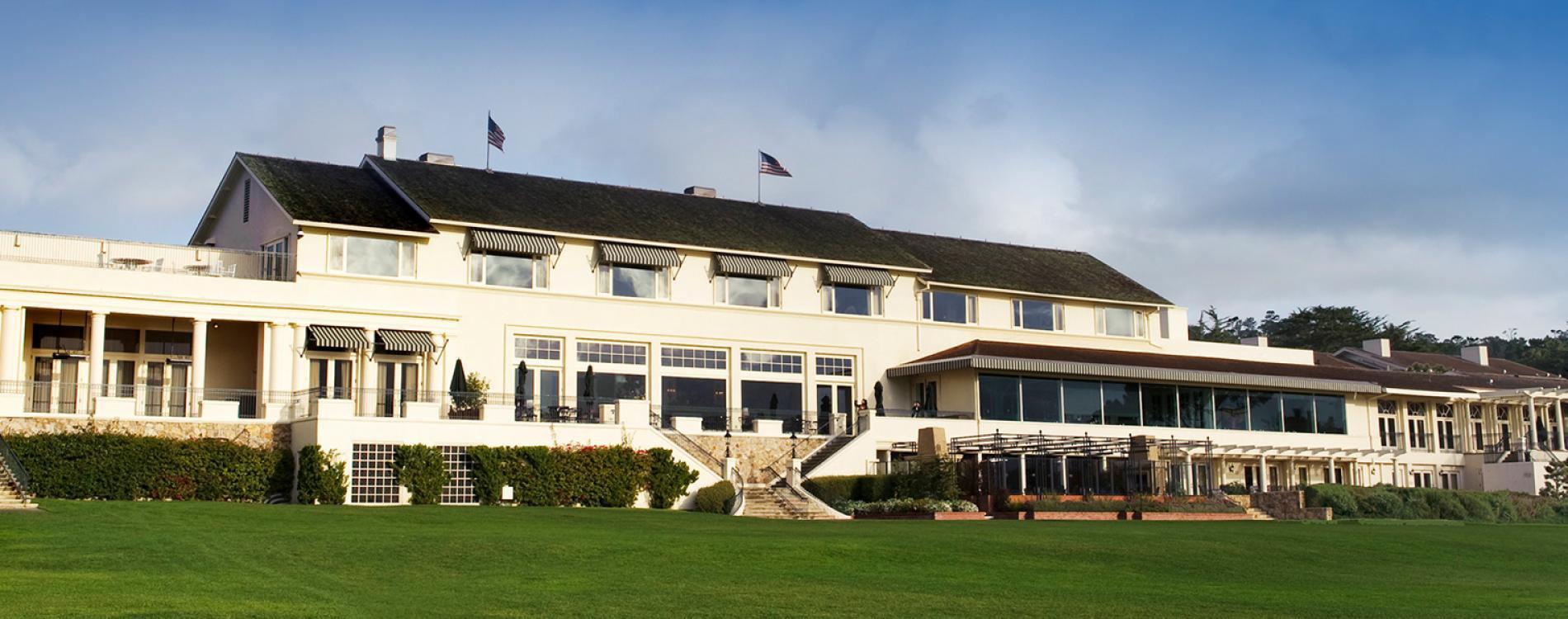 Exterior view of The Lodge's clubhouse overlooking the course with the american flag proudly swaying in the wind