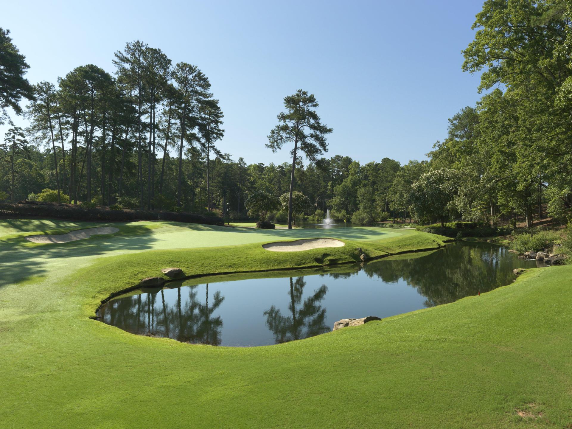 A sand bunker sandwiched between a water feature and manicured green