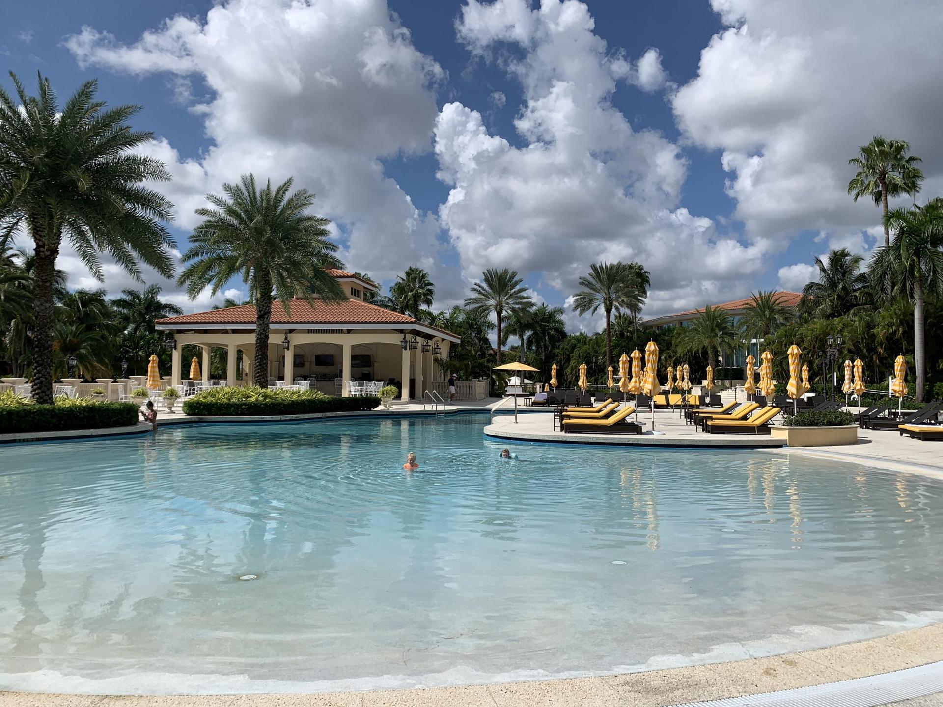 Swimming pool at the resort with yellow sun beds and umbrellas