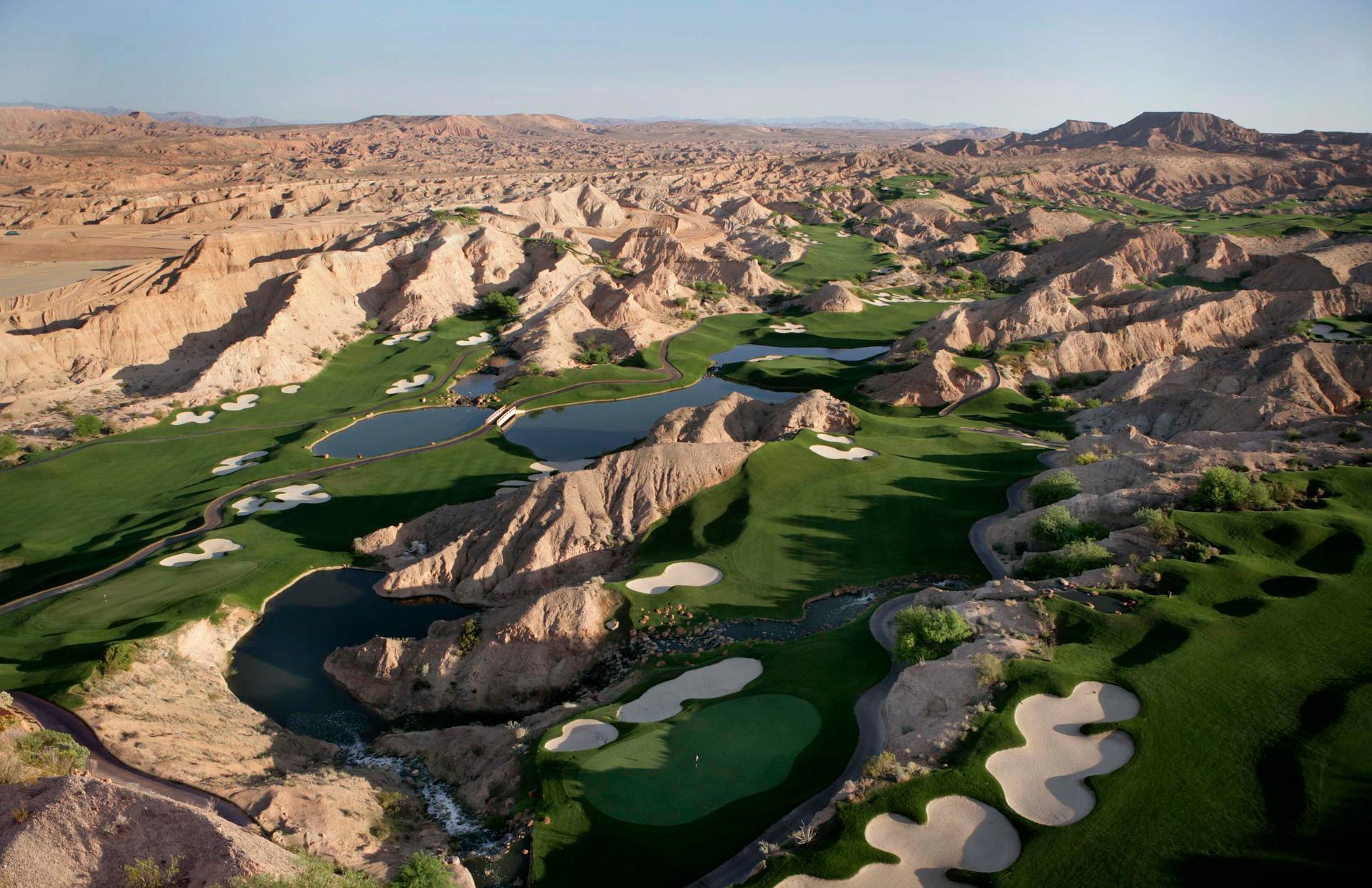 Aerial view of The Wolf Creek Golf Course littered with sand bunkers, water hazards and a mountainous rough