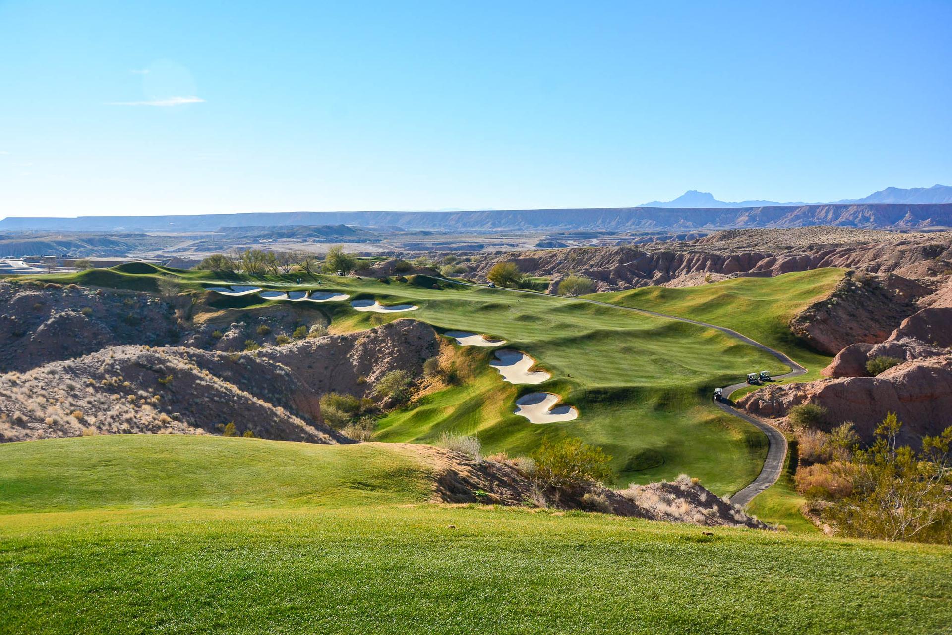 Panoramic view of a winding fairway with multiple sand bunkers placed all the way down the left side