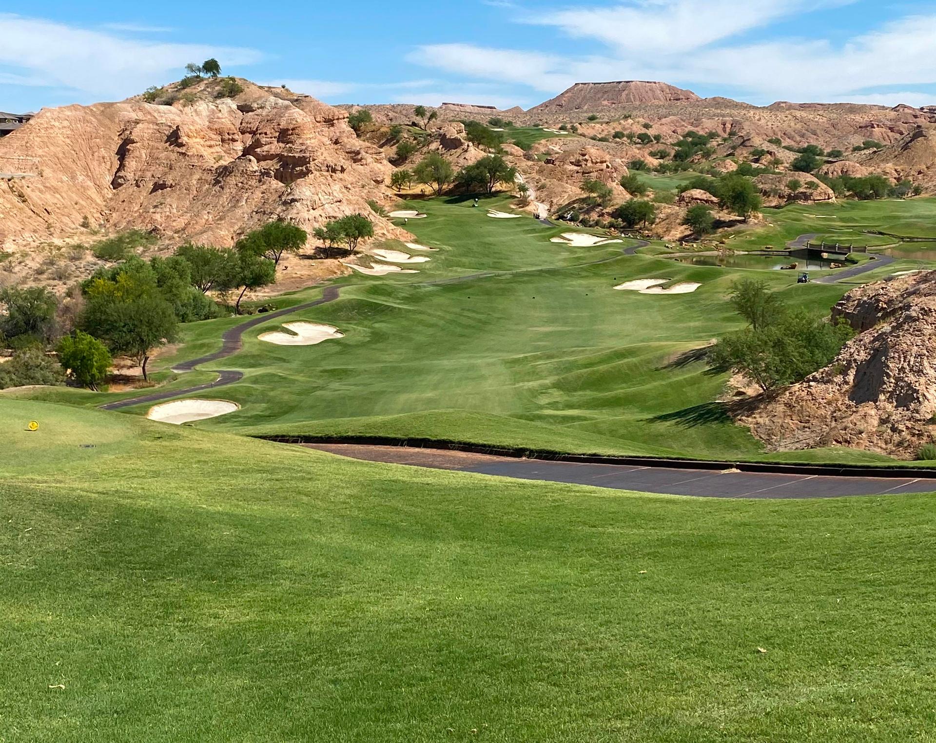 A wide fairway being sandwiched between uniquely shaped sand bunkers