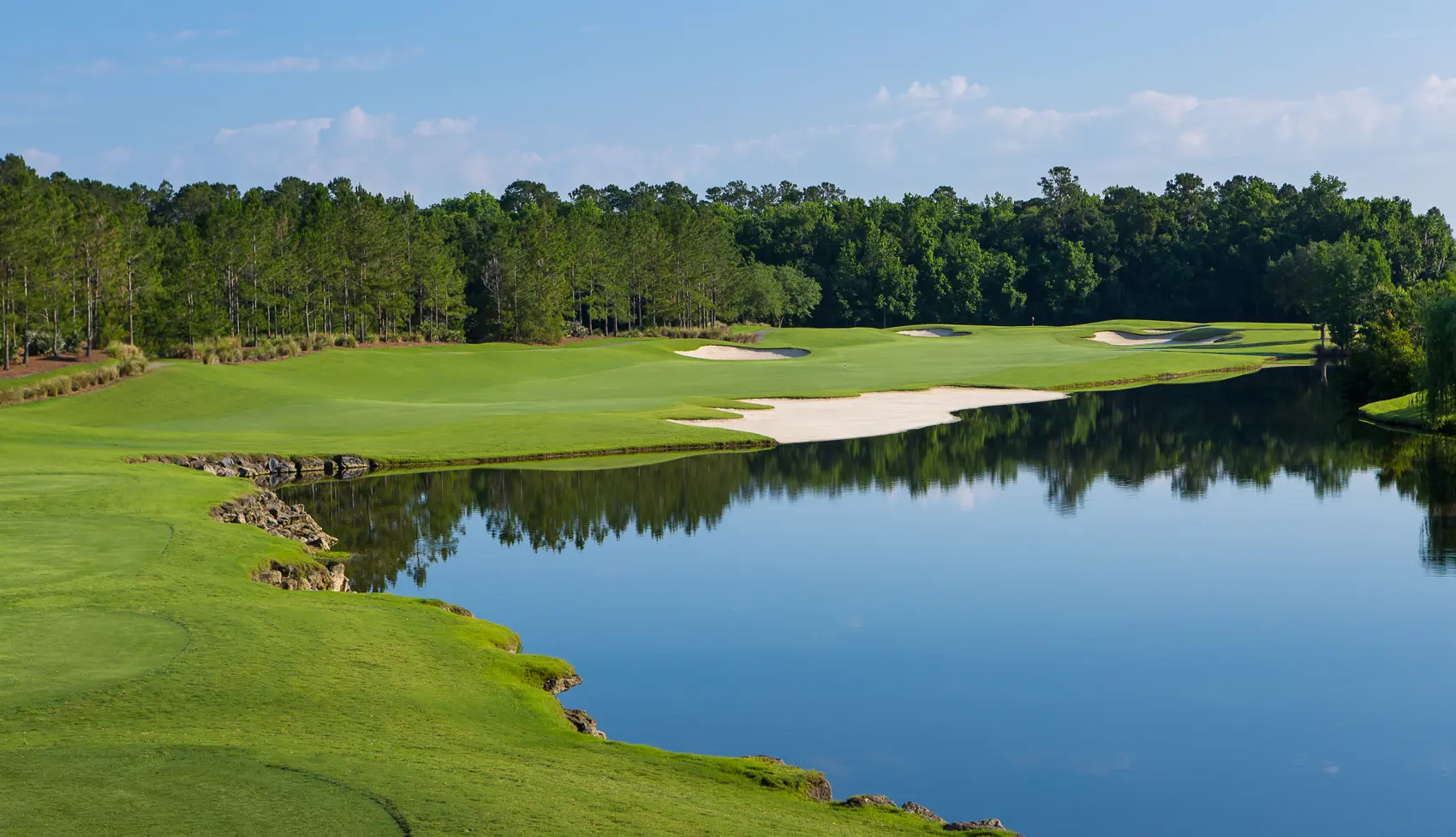 Wide fairway littered with sand bunkers leading to a smooth green on the course