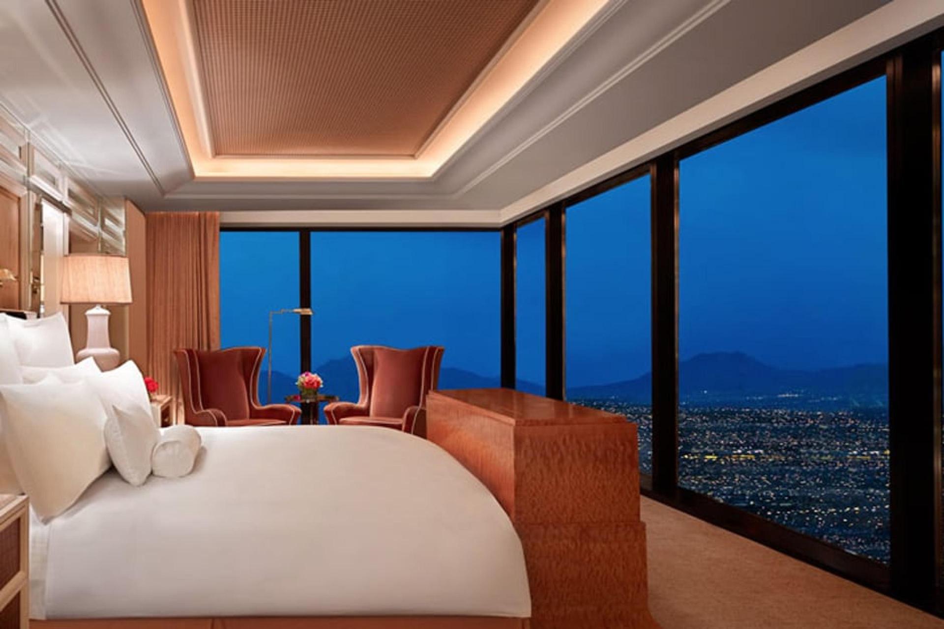 Modern luxurious double bed suite with a panoramic window showcasing Vegas views