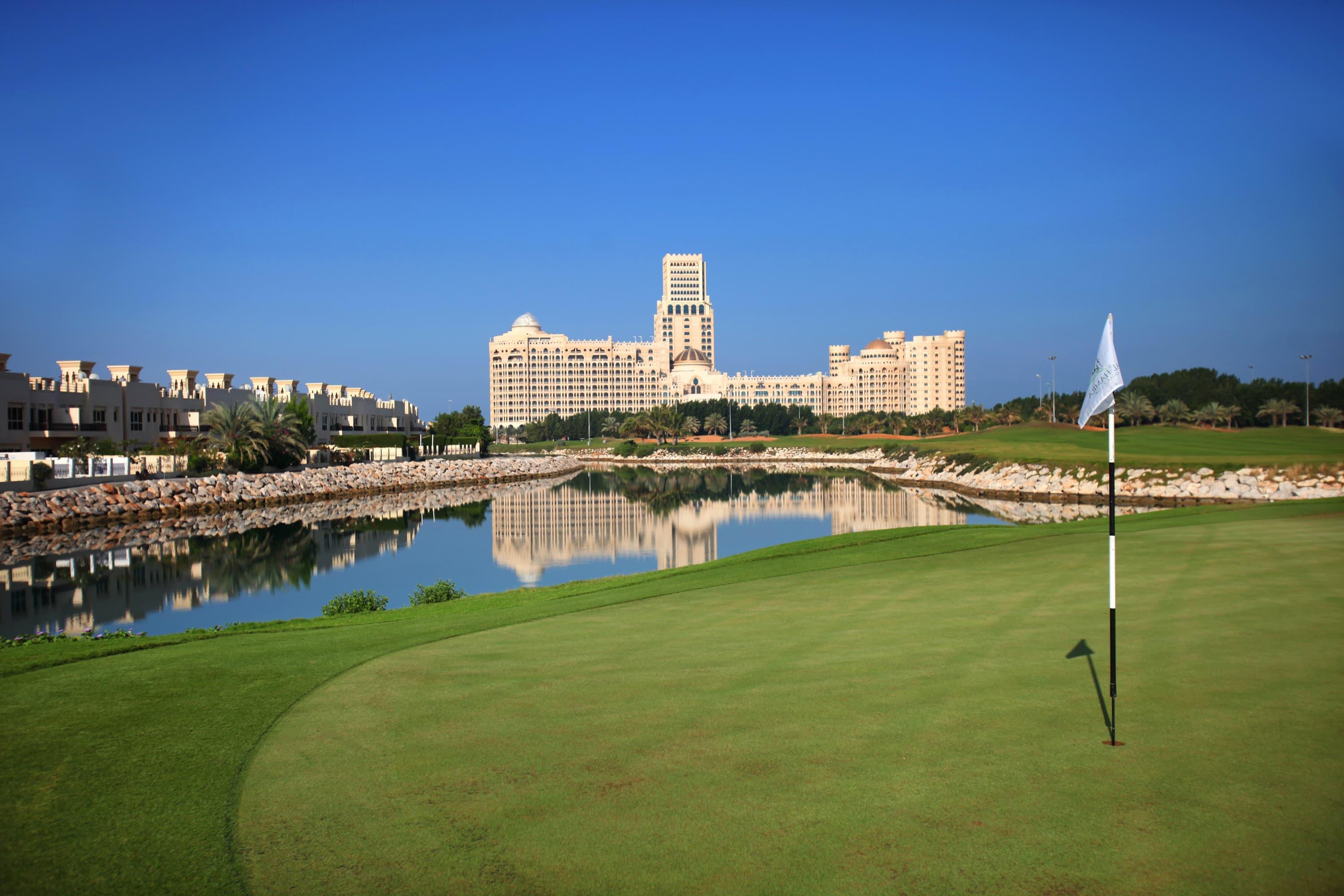 A smooth green strategically placed next to a water hazard with the hotel reflecting off the water