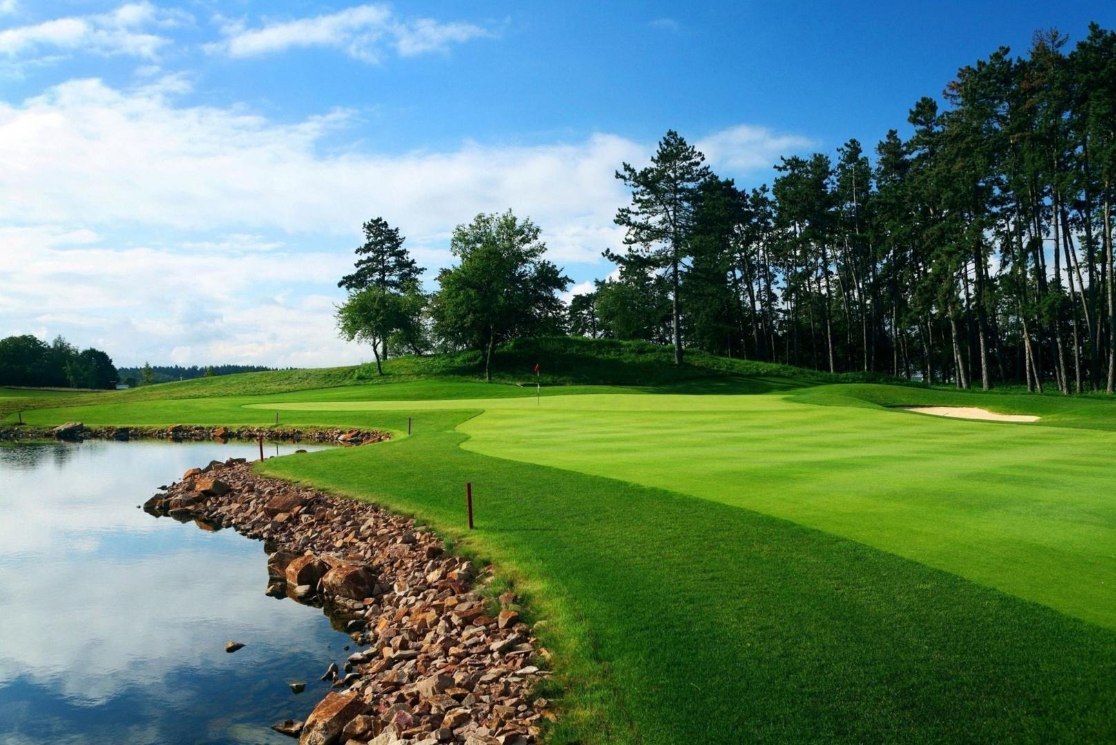 A fairway leading to a smooth green next to a river water hazard