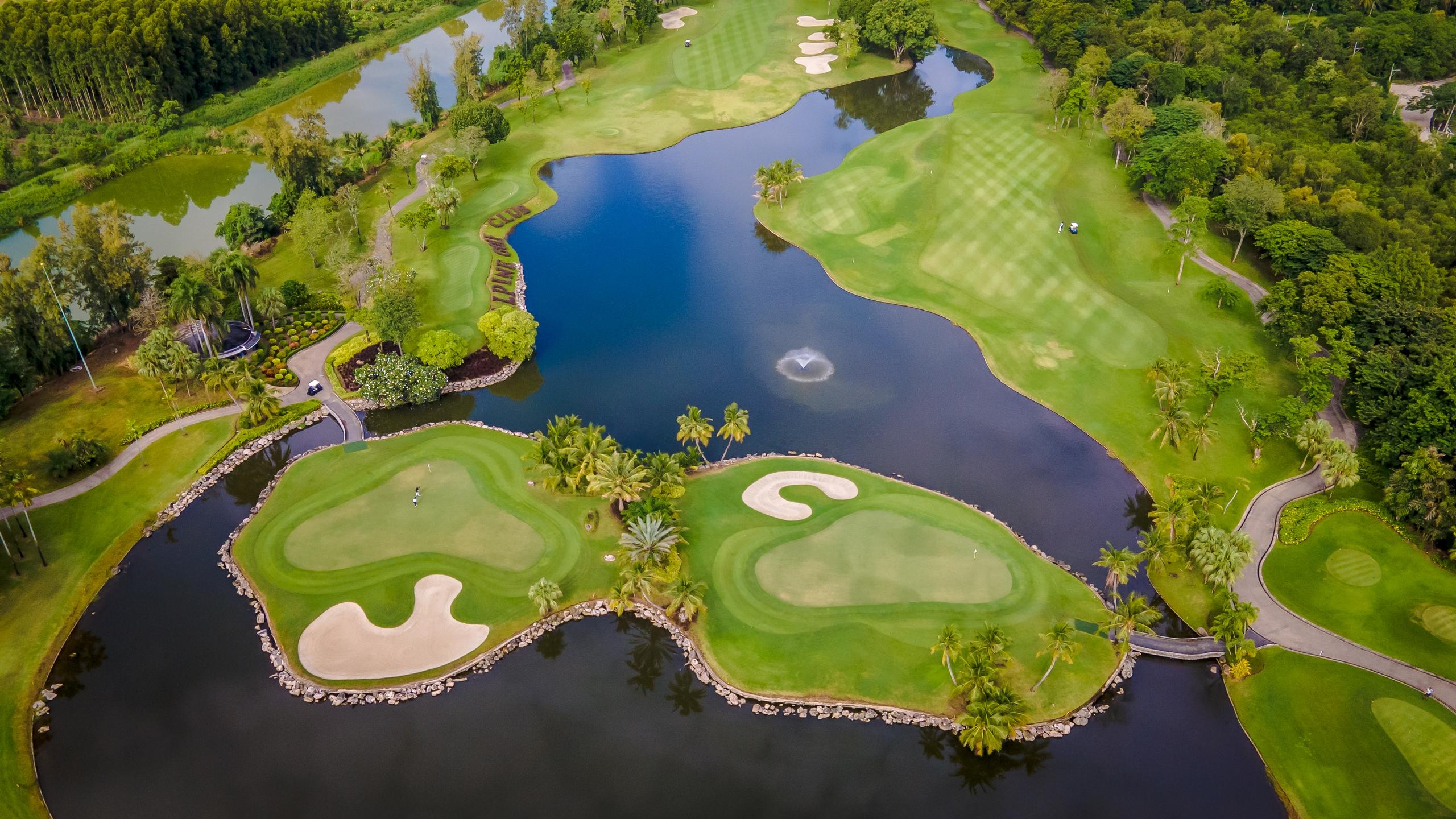 An aerial view of a lush golf course with interconnected lakes and islands.