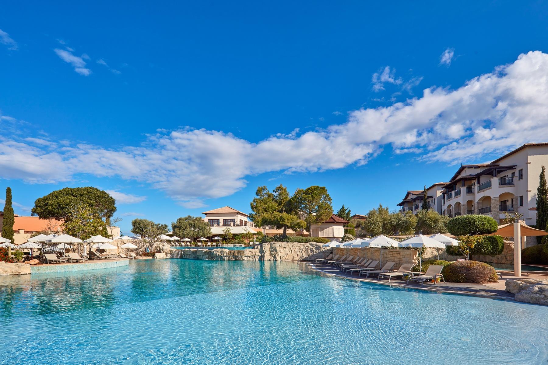 Panoramic view of an empty outdoor swimming pool with the resorts buildings surrounding